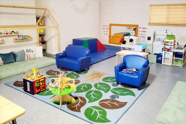 Cozy Bloom Early Learning Academy play area with soft rug and reading nook